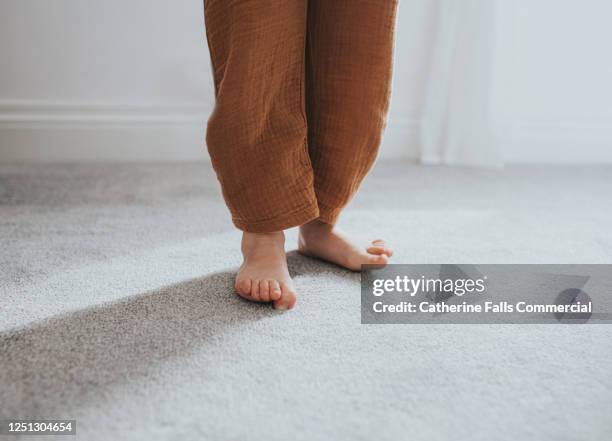 child's wiggling toes on grey thick pile carpet, casting shadow - nylon feet stock pictures, royalty-free photos & images