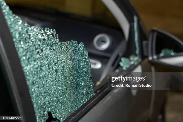 broken passenger window, car theft in the underground parking. - broken window stock-fotos und bilder