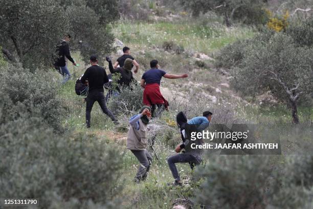 Palestinian protesters throw rocks at Israeli soldiers during a protest in the village of Beita, south of Nablus in the occupied West Bank, on April...