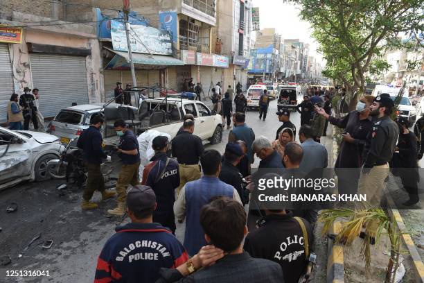Police officials examine the site of a bomb blast in Quetta on April 10, 2023. - At least four people were killed and 15 others injured on April 10...