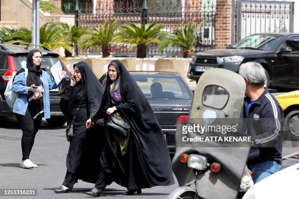 Iranian women walk in a street in Tehran on April 10, 2023. - Police in Iran said on April 8 they plan to use "smart" technology in public places to...