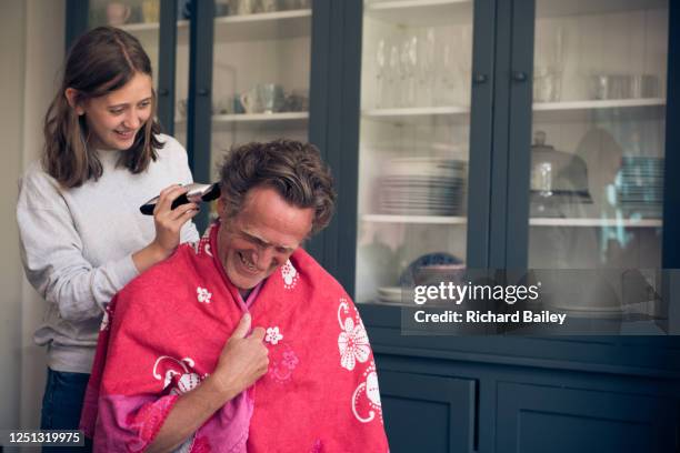 home haircut - teenage daughter giving her father a 'lockdown' haircut - lockdown haircut stock pictures, royalty-free photos & images