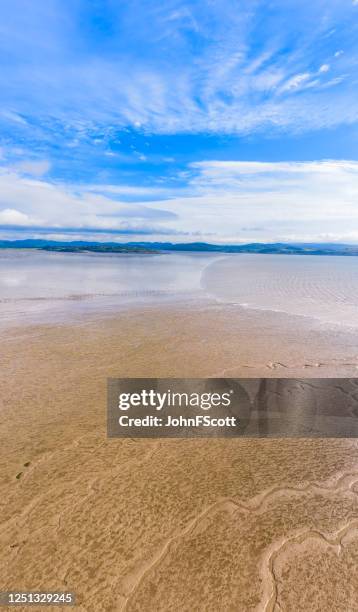 vertikaler panoramablick auf sand, wenn die flut an einem hellen sonnigen morgen im südwesten schottlands hereinkommt - ebbe stock-fotos und bilder