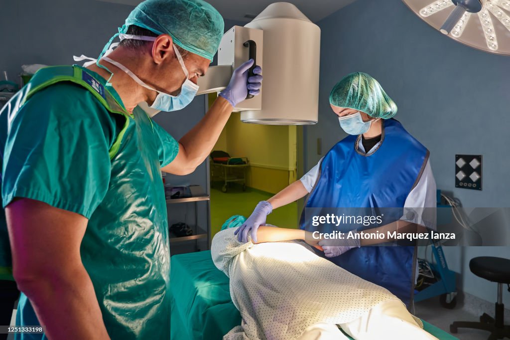 X-ray machine in operating room, nurse positioning arm