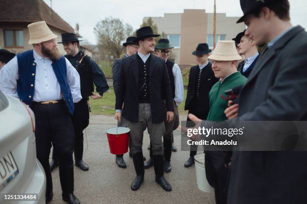 Boys and younger men from the Ilosvai Selymes Peter folk dance group prepare buckets of cold water as they attend the traditional watering of local...