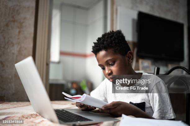 enfant avec l’ordinateur portatif sur une classe en ligne à la maison - attentif photos et images de collection