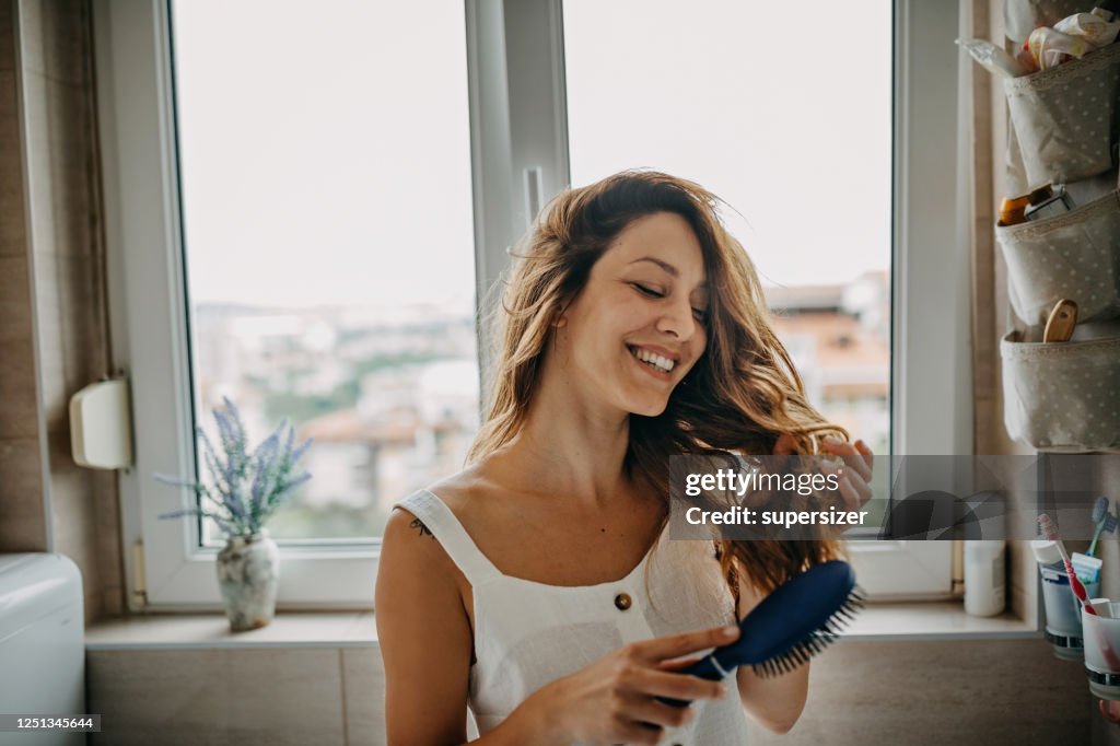Mujer joven peinando el cabello