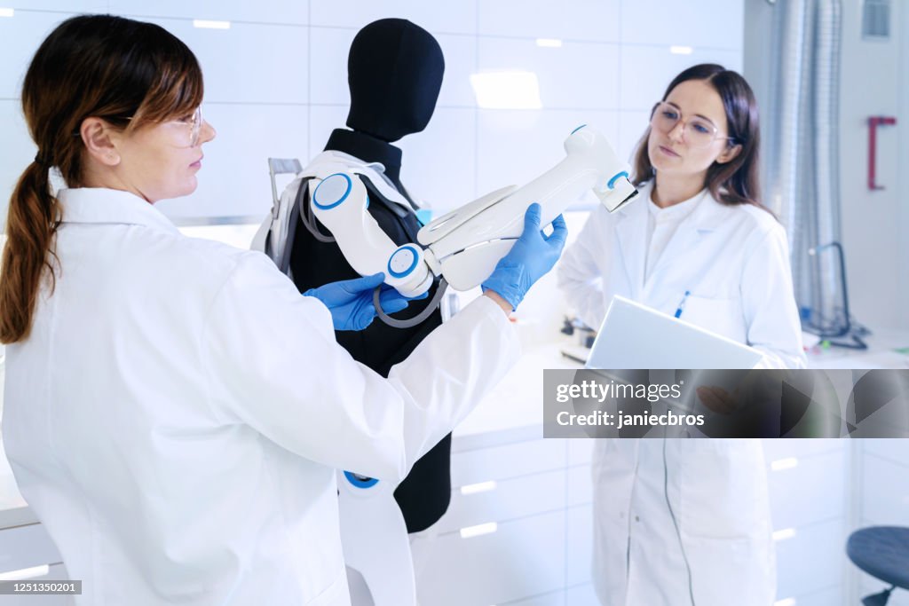 Vrouwelijk Laboratoriumteam aan het werk. Human Exoskelet Project