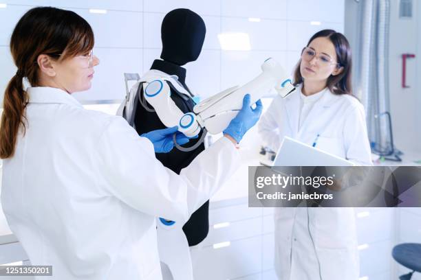 female laboratory team at work. human exoskeleton project - exoskeleton stock pictures, royalty-free photos & images