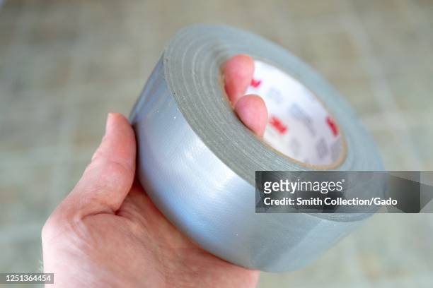 Close-up of hand of man holding roll of duct tape, San Ramon, California, June 18, 2020.