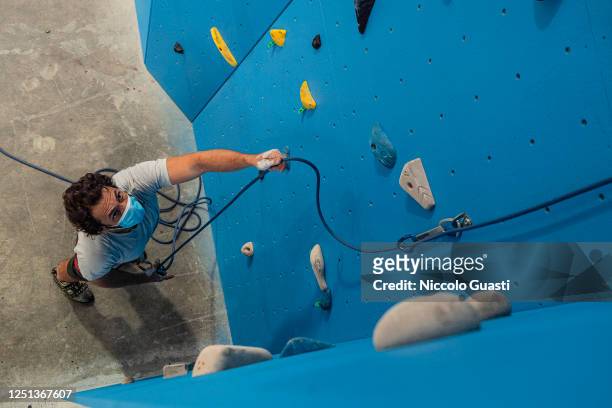Climber David Marcos holds a rope while belaying a climber at Rock&wall Climbing Gym on the day of reopening after the lockdown on June 22, 2020 in...