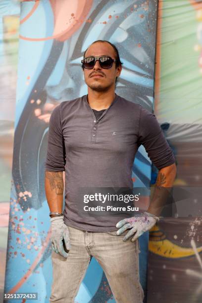 Artist Raphe is seen painting a piece outside L'eurpeen theater on the day of the reopening on June 22, 2020 in Paris, France.