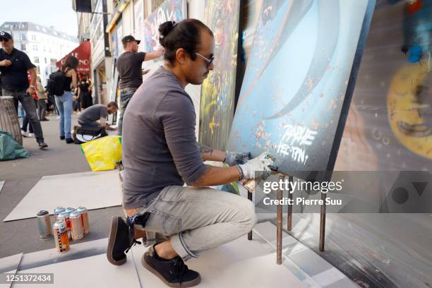 Artist Raphe is seen painting a piece outside L'eurpeen theater on the day of the reopening on June 22, 2020 in Paris, France.