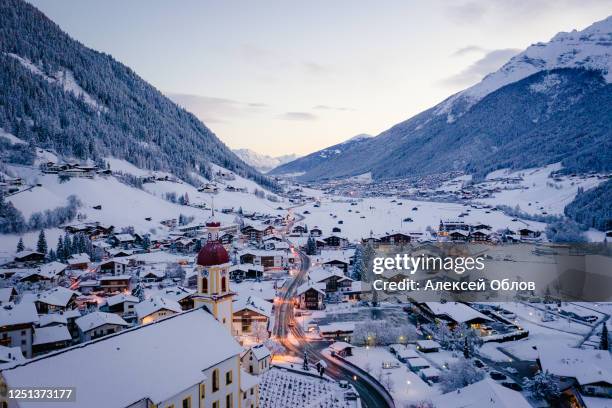 winter morning cityscape in the austrian town of neustift. aerial view of the town center and the church. morning illumination of houses and traffic light. tyrol, stubai valley - neustift im stubaital stock pictures, royalty-free photos & images