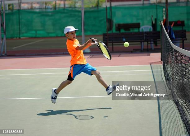 a boy is playing tennis on the hardcourt with forehand - tennis stock pictures, royalty-free photos & images