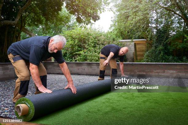 rolling out new artificial grass - turf installation stock pictures, royalty-free photos & images