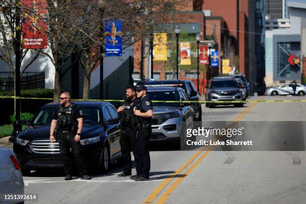 Police officers gather outside the front entrance of the Old National Bank building after a gunman opened fire on April 10, 2023 in Louisville,...