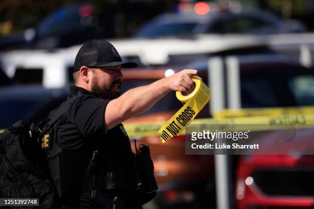 Law enforcement officer carries a roll of crime scene tape after a gunman opened fire at the Old National Bank building on April 10, 2023 in...