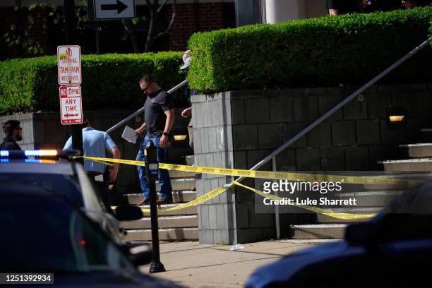Law enforcement officers gather outside the front entrance of the Old National Bank building after a gunman opened fire on April 10, 2023 in...