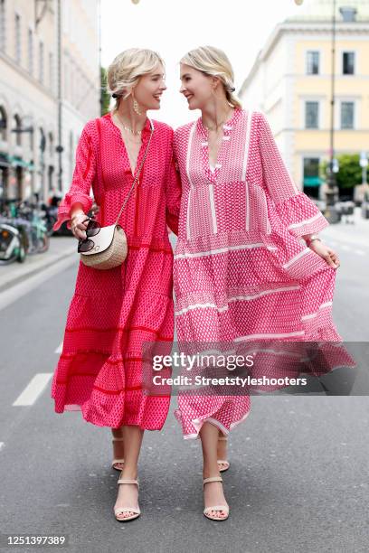 Advertising twins Nina Meise and Julia Meise, waering a red-pink and a red-white bohemian style maxi dress by Mooi Fashion Berlin, a small bast fiber...