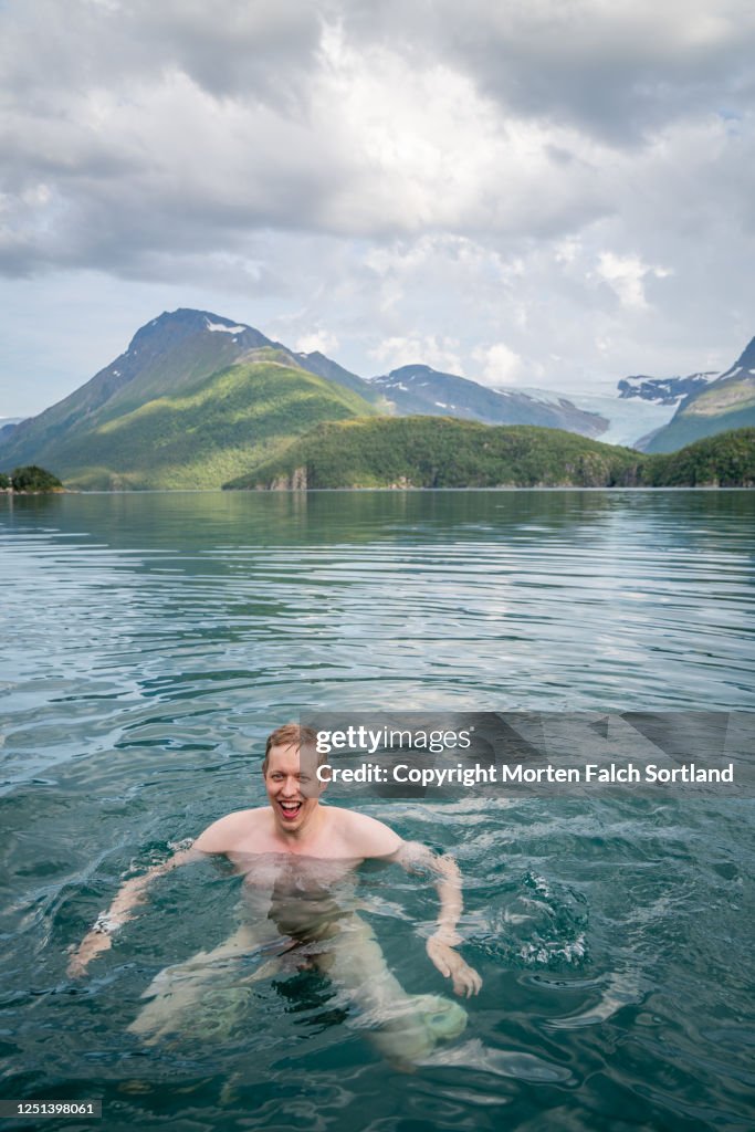 Young man skinny-dipping in a lake in Halsa, Norway