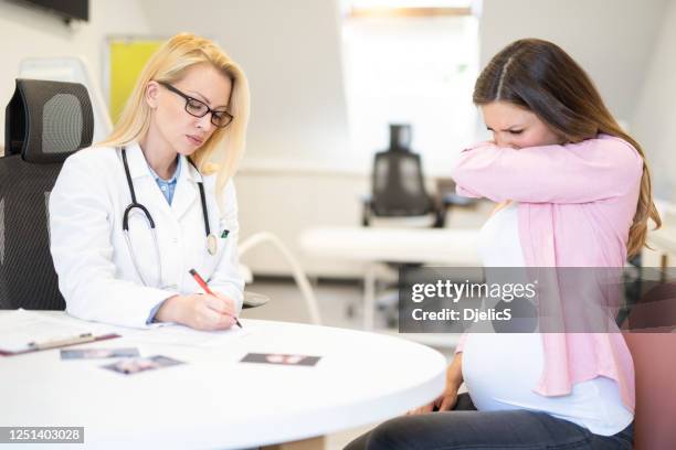 young woman on pregnancy exam during covid 19. - covering cough stock pictures, royalty-free photos & images