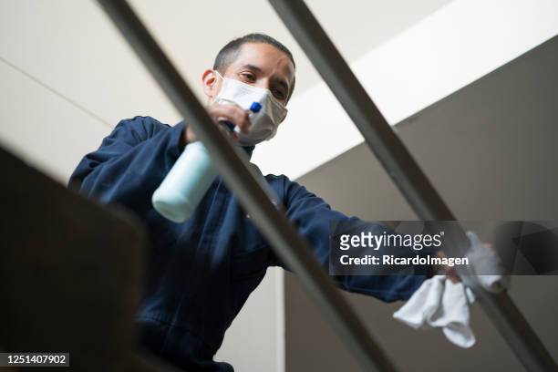 janitor cleans the stairs of the building where he works while wearing his mask - general view stock pictures, royalty-free photos & images