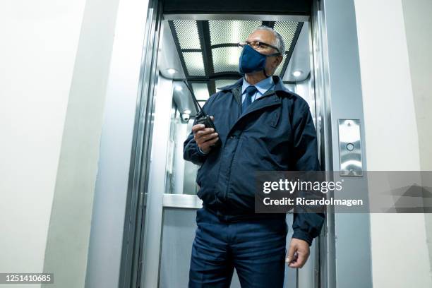 latin ethnic man, warden of a building, inside an elevator during the covid-19 - general view stock pictures, royalty-free photos & images