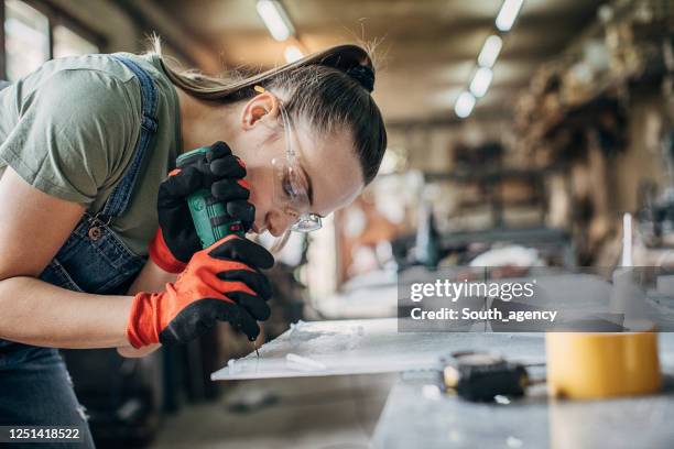 woman manual worker working in workshop - glove imagens e fotografias de stock
