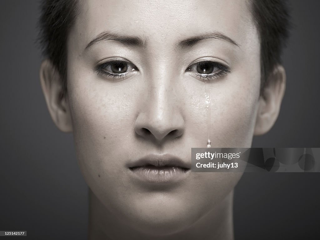 Portrait of young Asian girl with tear rolling down cheek