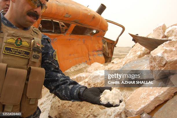 Iraqi security forces inspect an explosives-laden truck which was driven by a suicide bomber and exploded partially due to an error in the connection...