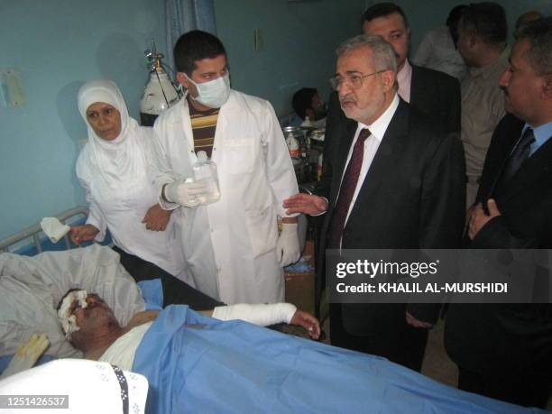 Iraqi parliament speaker and deputy of the Islamic party Iyad al-Samarrai vists an injured man caught in yesterday's suicide bombings as he lies in a...