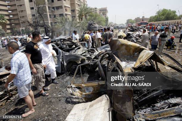 People gather at the scene of a massive explosion outside the foreign ministry in a residential area close to the Green Zone in central Baghdad on...