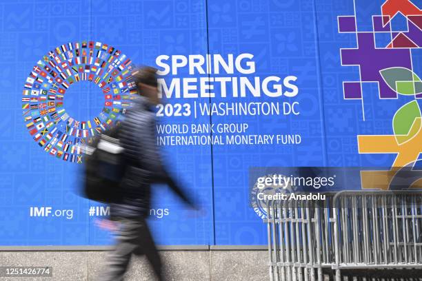 Person walks past a sign for the 2023 Spring Meetings of the World Bank/International Monetary Fund in Washington DC, United States on April 10, 2023.