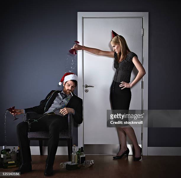 businesswoman pouring drink over colleague - passed out drunk stockfoto's en -beelden