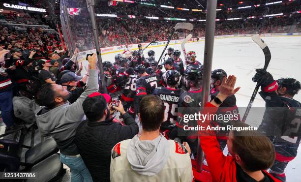 Claude Giroux of the Ottawa Senators celebrates his 1000th career NHL point with teammates during the first period of a game against the Carolina...