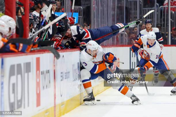 Tom Wilson of the Washington Capitals and Adam Pelech of the New York Islanders collide during a game at Capital One Arena on April 10, 2023 in...