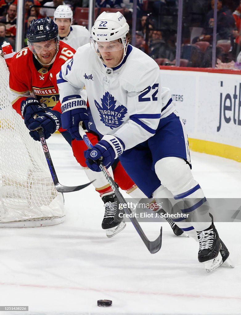 Jake McCabe of the Toronto Maple Leafs attempts to gather the puck