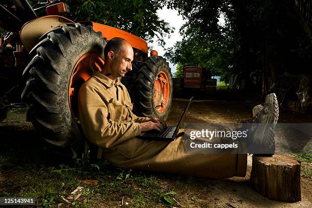 farmer using a laptop in his farmyard.color image - unexpected stock pictures, royalty-free photos & images