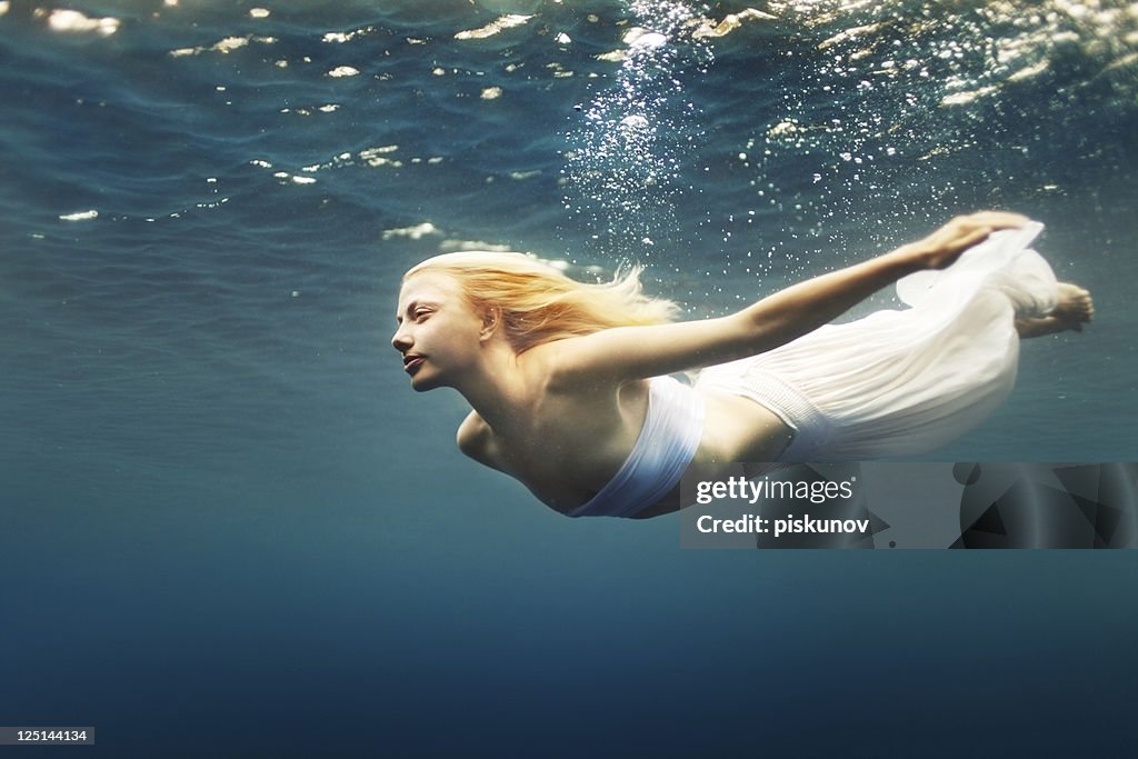 Young woman dive into deep water