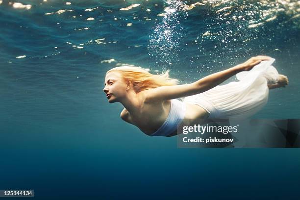 young woman dive into deep water - underwater female models stock pictures, royalty-free photos & images