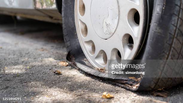 flat tire of an old rusty car close up - flat tire fotografías e imágenes de stock