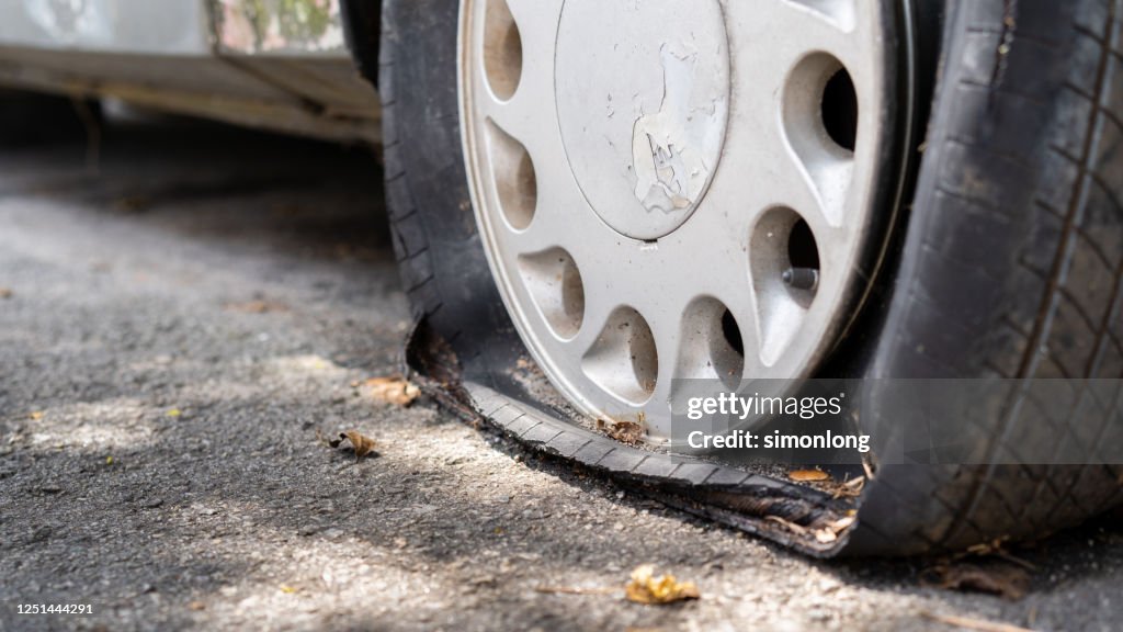 Flat tire of an old rusty car close up