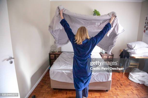 a teenage girl making her bed at home. - tidy room teen stock pictures, royalty-free photos & images
