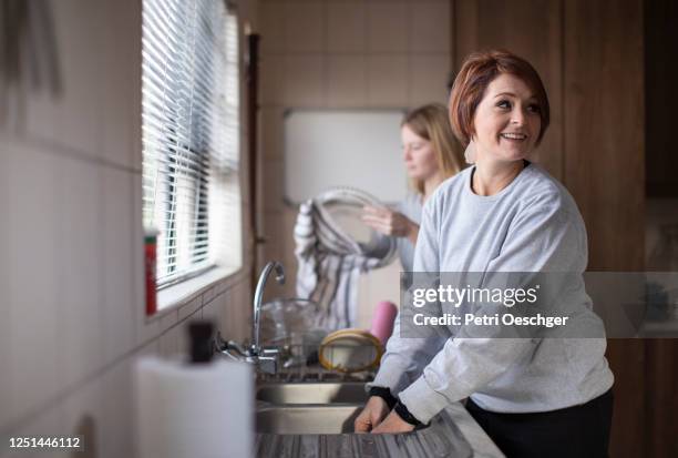 a mother and her sixteen-year-old daughter doing the dishes together. - 16 year stock pictures, royalty-free photos & images