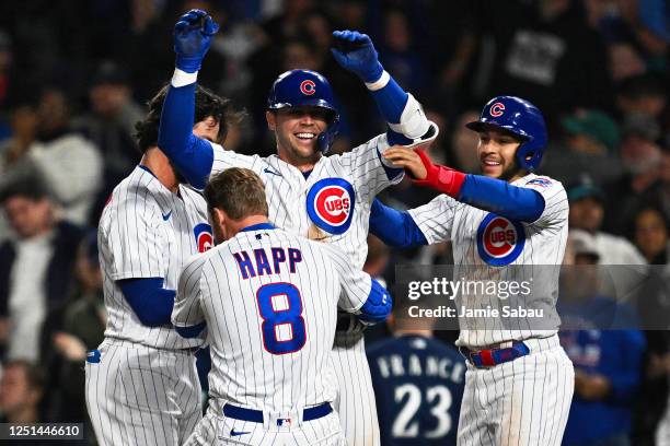 Nico Hoerner of the Chicago Cubs celebrates his walk-off RBI single with Ian Happ and Nick Madrigal, who scored, in the 10th inning against the...