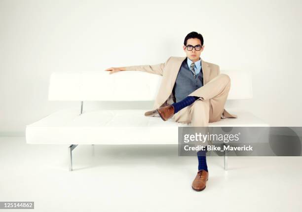 well-dressed man sitting on a white bench - legs crossed at knee stock pictures, royalty-free photos & images