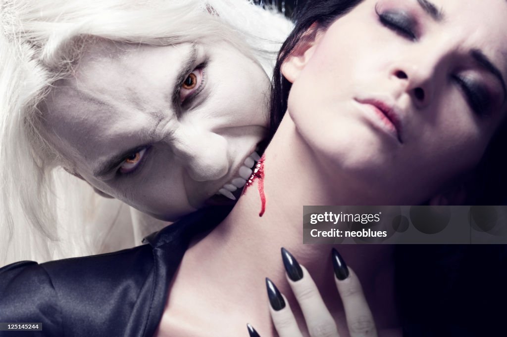 Male Vampire is biting a beautiful woman.