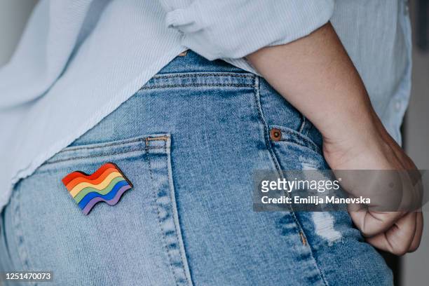 close up of woman wearing rainbow badge - brooch stock-fotos und bilder