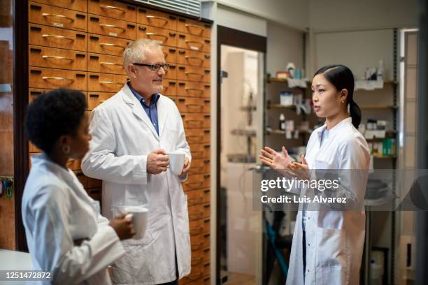 group of pharmacists having a coffee break - speaking explaining young woman stock-fotos und bilder